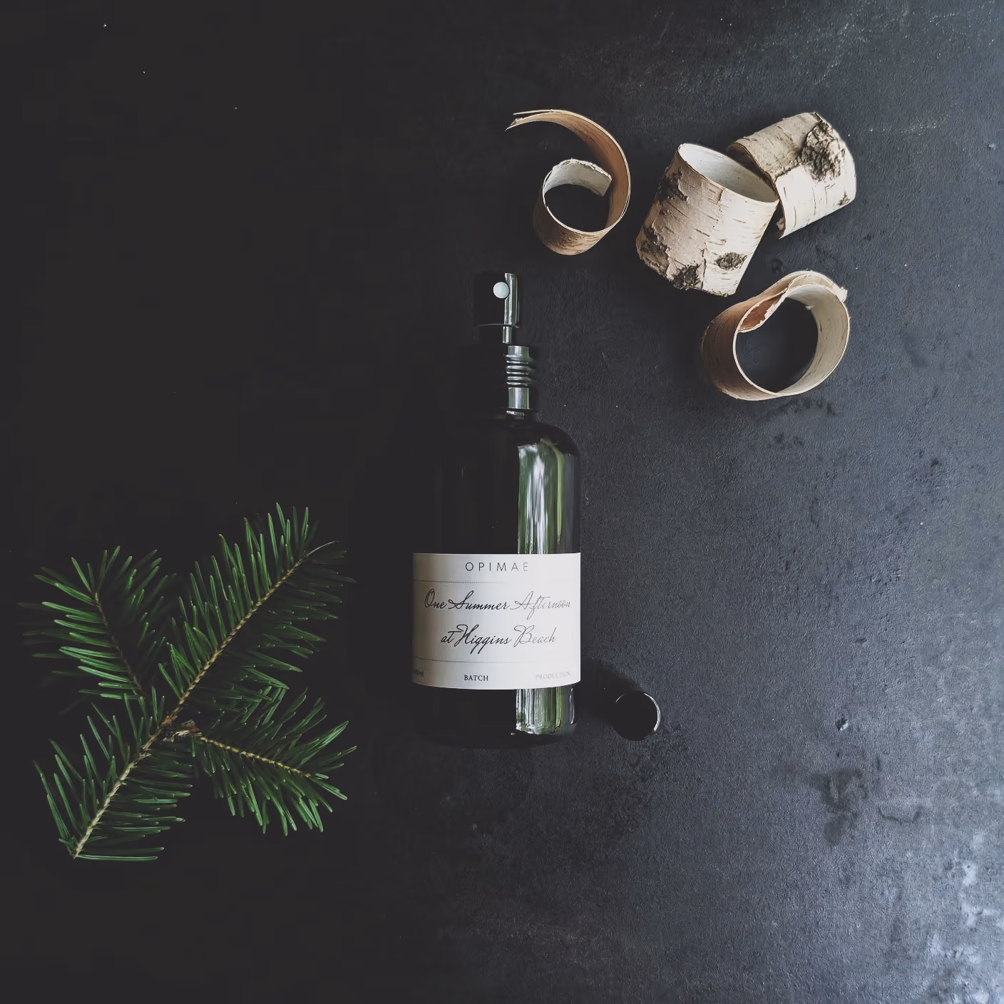 Opimae home perfume surrounded by its raw ingredients