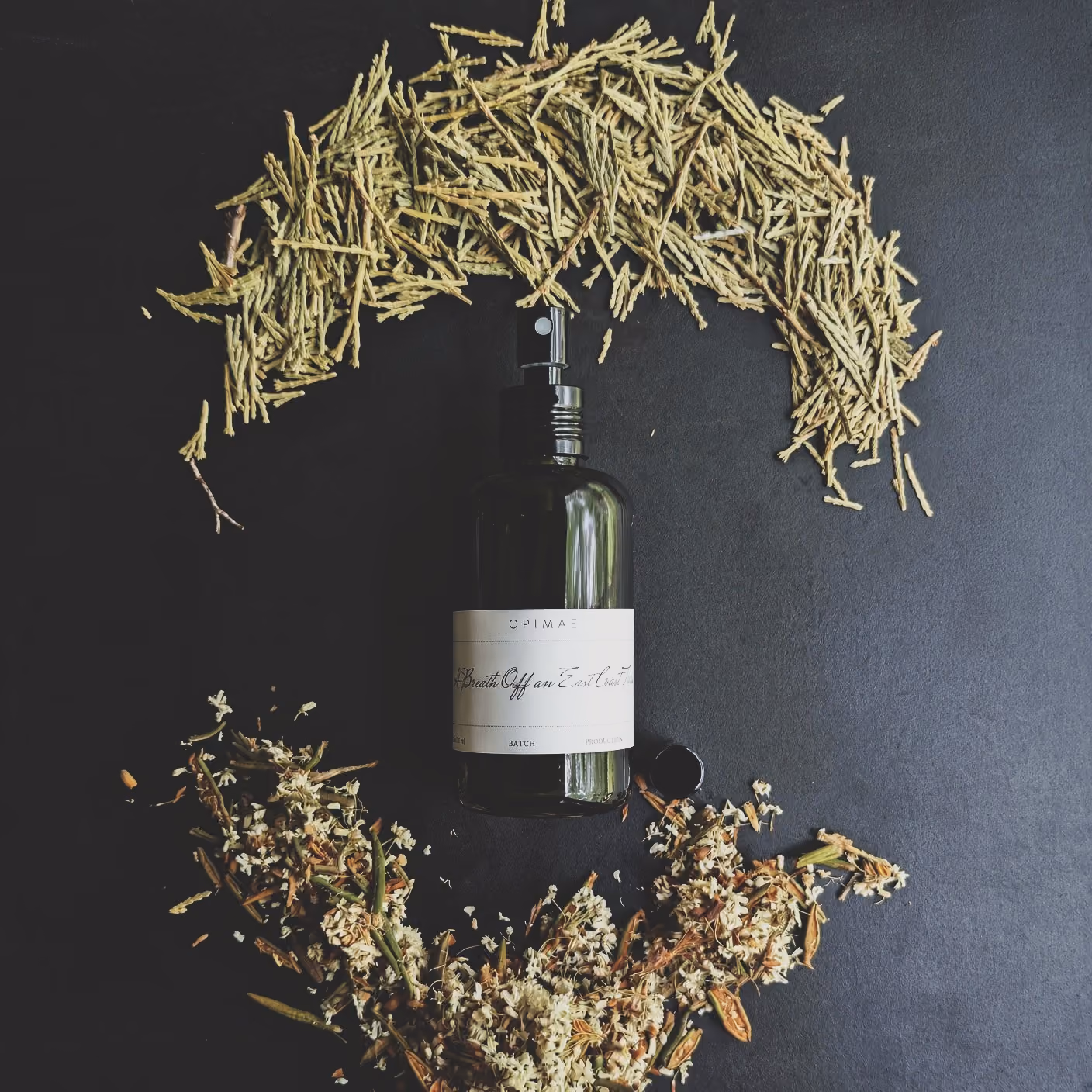 Opimae home perfume surrounded by its raw ingredients