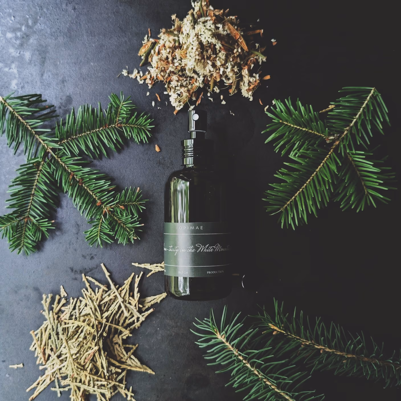 Opimae home perfume surrounded by its raw ingredients