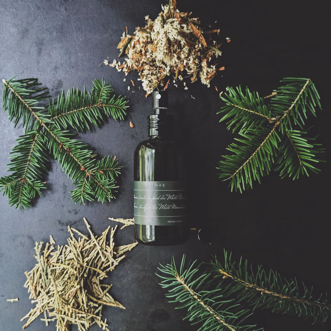 Parfum d'ambiance Opimae entouré de ses ingrédients bruts