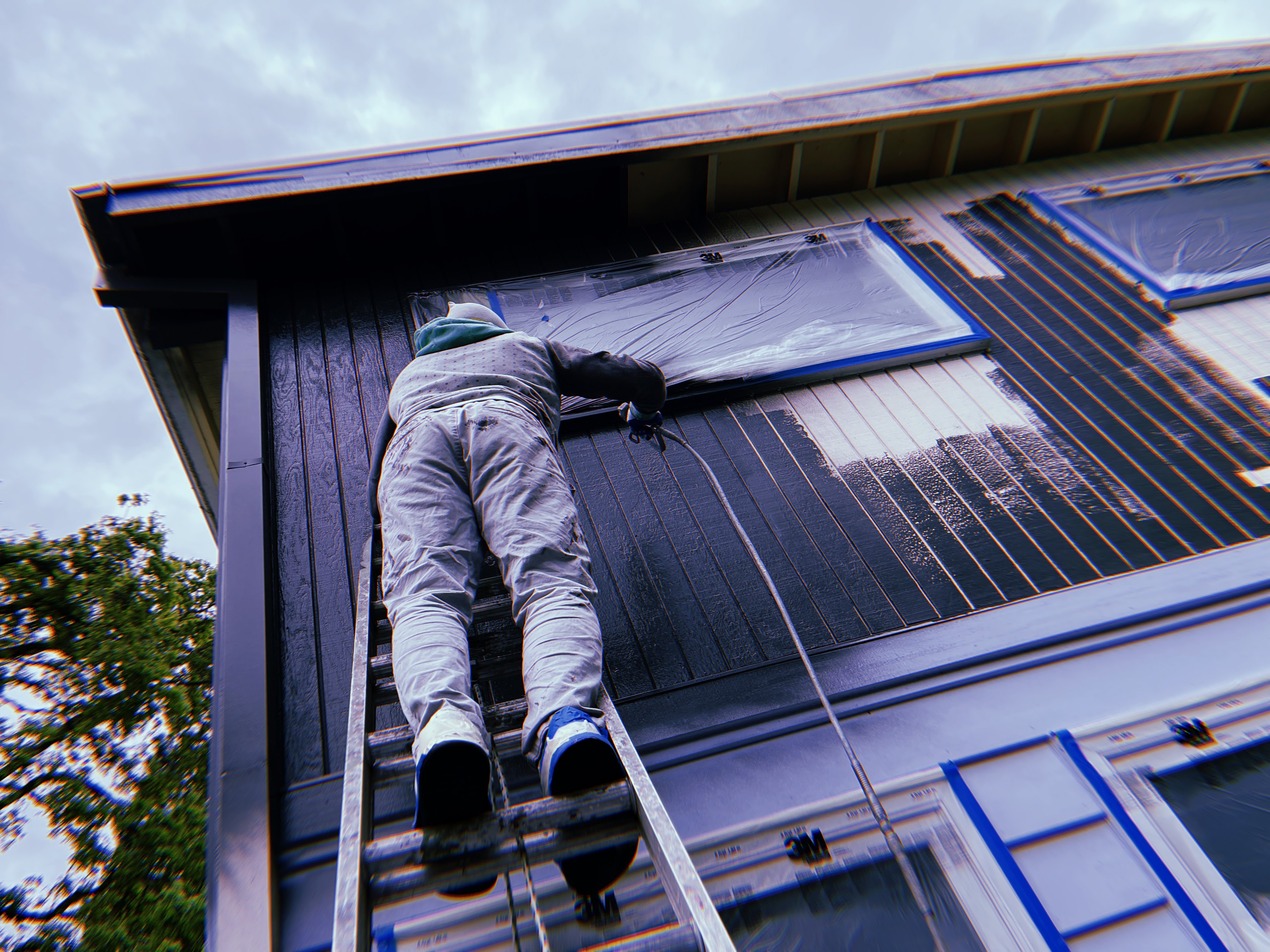 D'S Painting LLC crew member painting exterior siding on a ladder, Oregon residential project