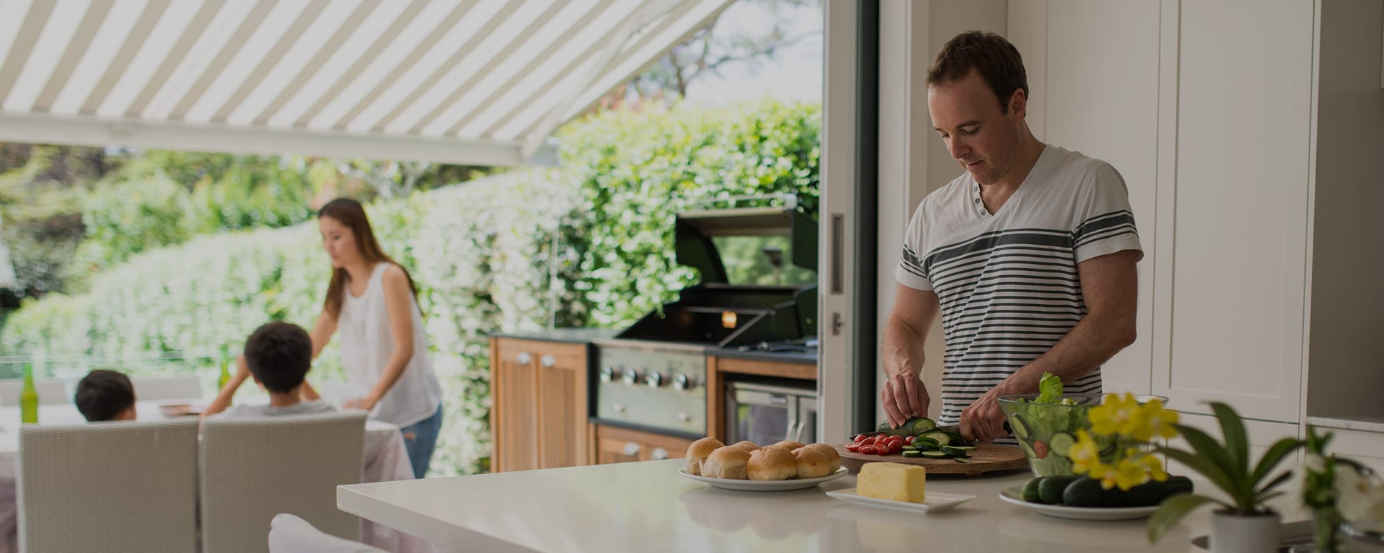 Family preparing food and dining in a modern indoor outdoor home space