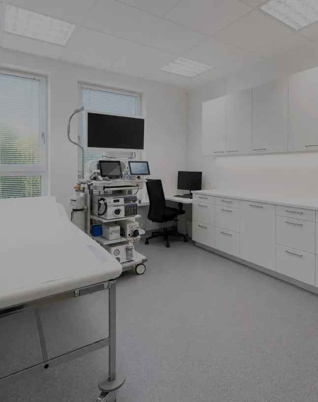 Wissenschaftler mit Schutzmaske und Haube inspiziert eine Flüssigkeit in einem Laborgefäß.