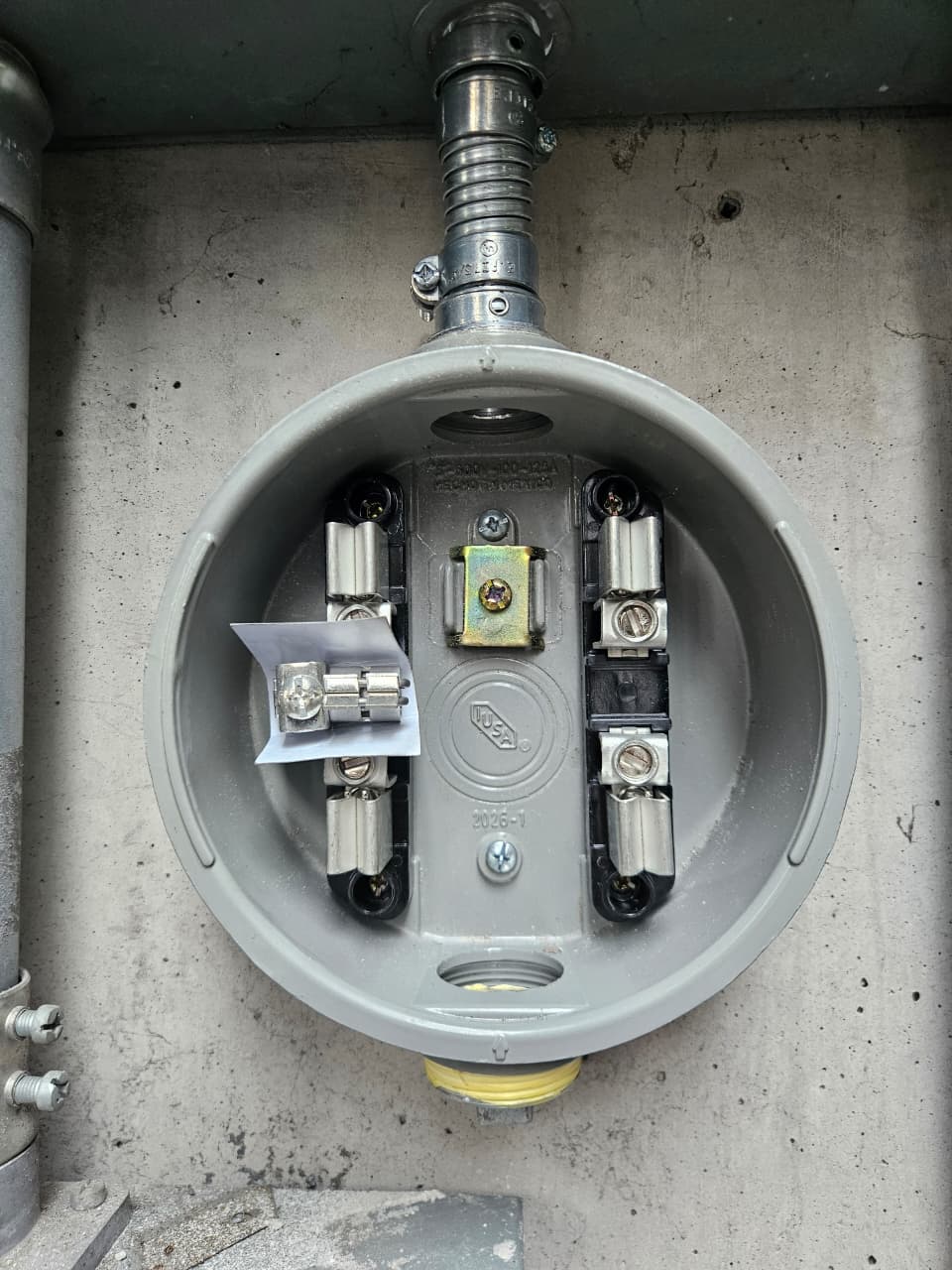 Base de medidor IUSA con mordazas de baquelita instalada y lista para conexión, priorizando la seguridad eléctrica.