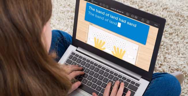 Student using an online typing program on a laptop