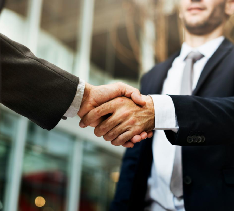 Two businessmen shaking hands in a professional setting.