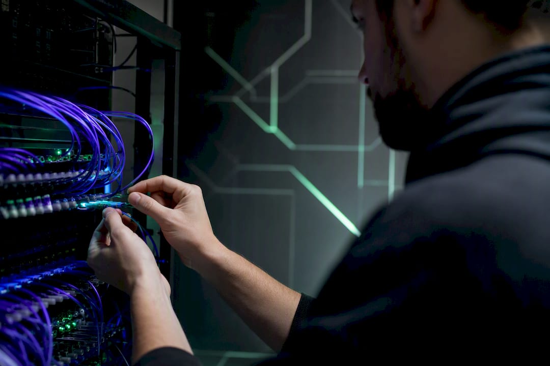 Hands adjusting glowing network cables