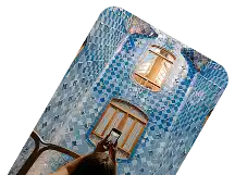 Curved interior courtyard wall covered with blue patterned tiles and windows, viewed from below.