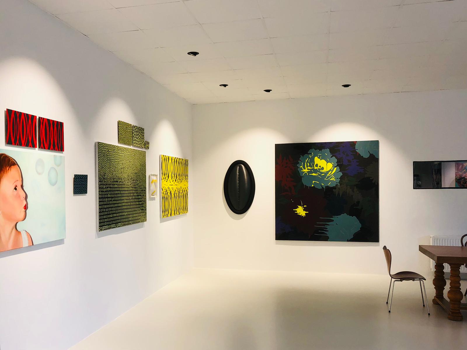 Kunstgalerie mit verschiedenen modernen Gemälden, darunter ein Porträt eines Kindes und abstrakte Muster.