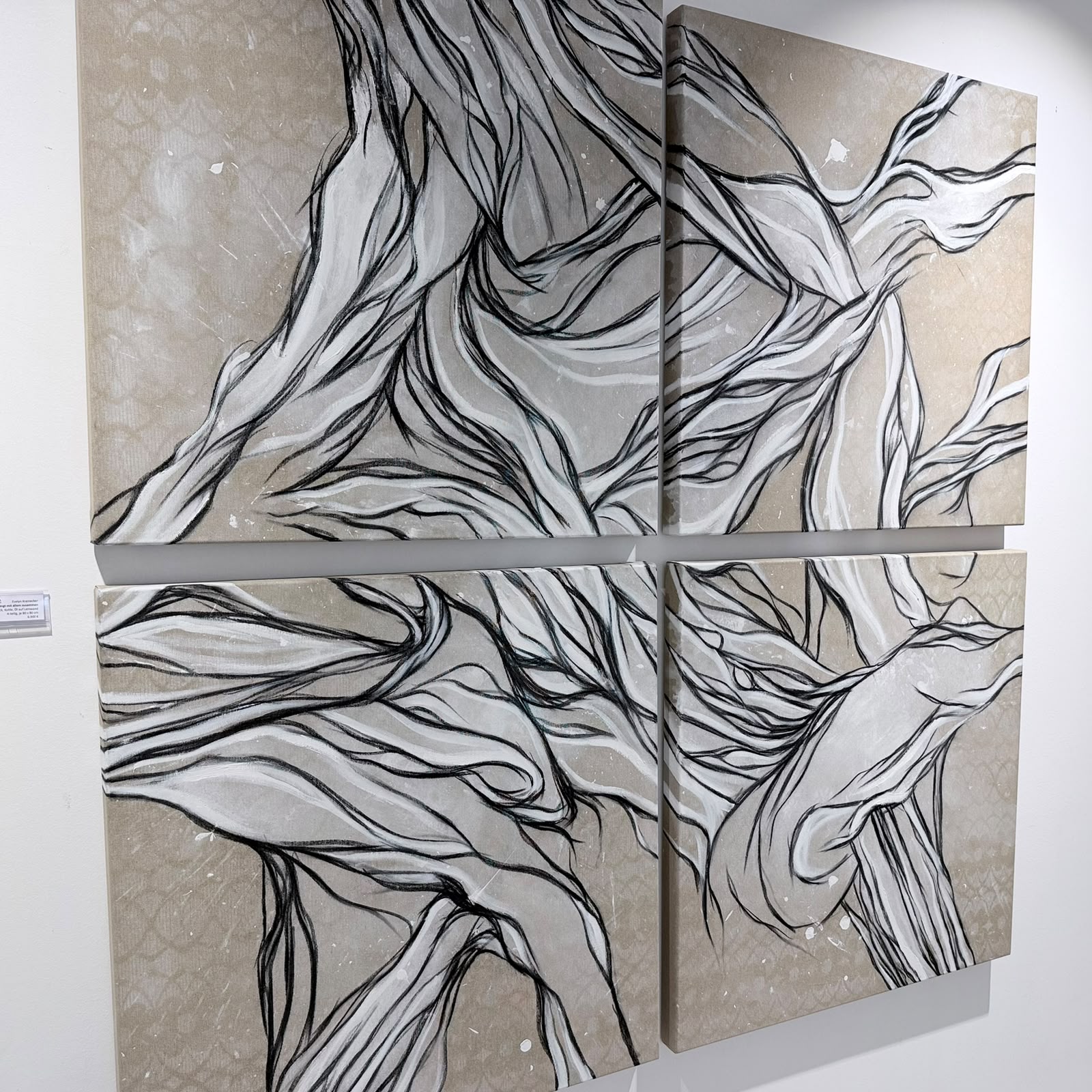 Vierteiliges abstraktes Gemälde an der Wand mit miteinander verbundenen, geschwungenen, schwarzen und weißen Linien auf einem beige-grauen Hintergrund, das organische, fließende Formen darstellt  in der PARK GALERIE Buchkirchen bei Wels mit Petuscha (Peti) Schopper.