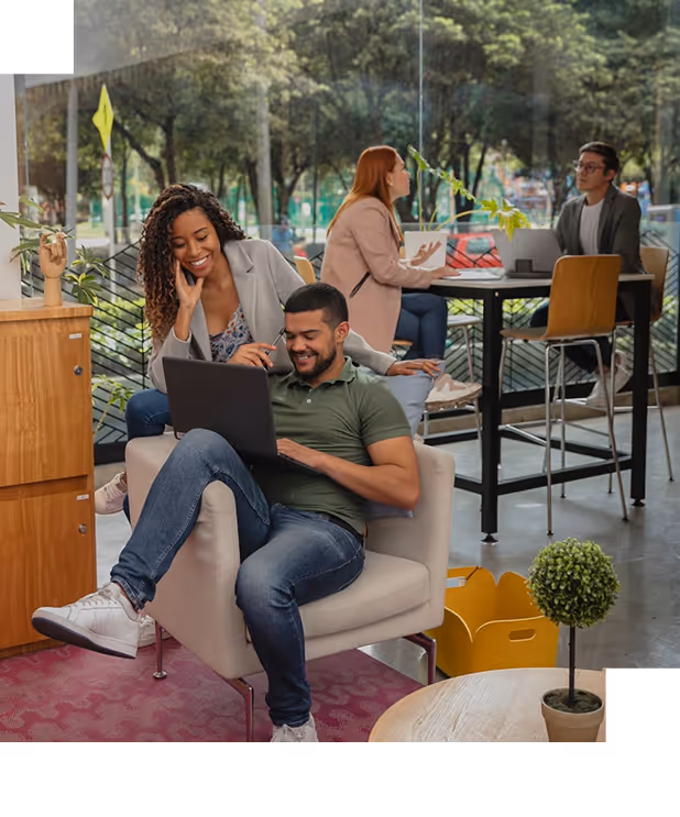 BBC - Quatre jeunes professionnels dans un espace de coworking avec ordinateur portable et discussion animée.