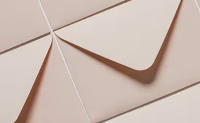 Des enveloppes beiges ouvertes et posées en chevauchement sur une surface claire.
