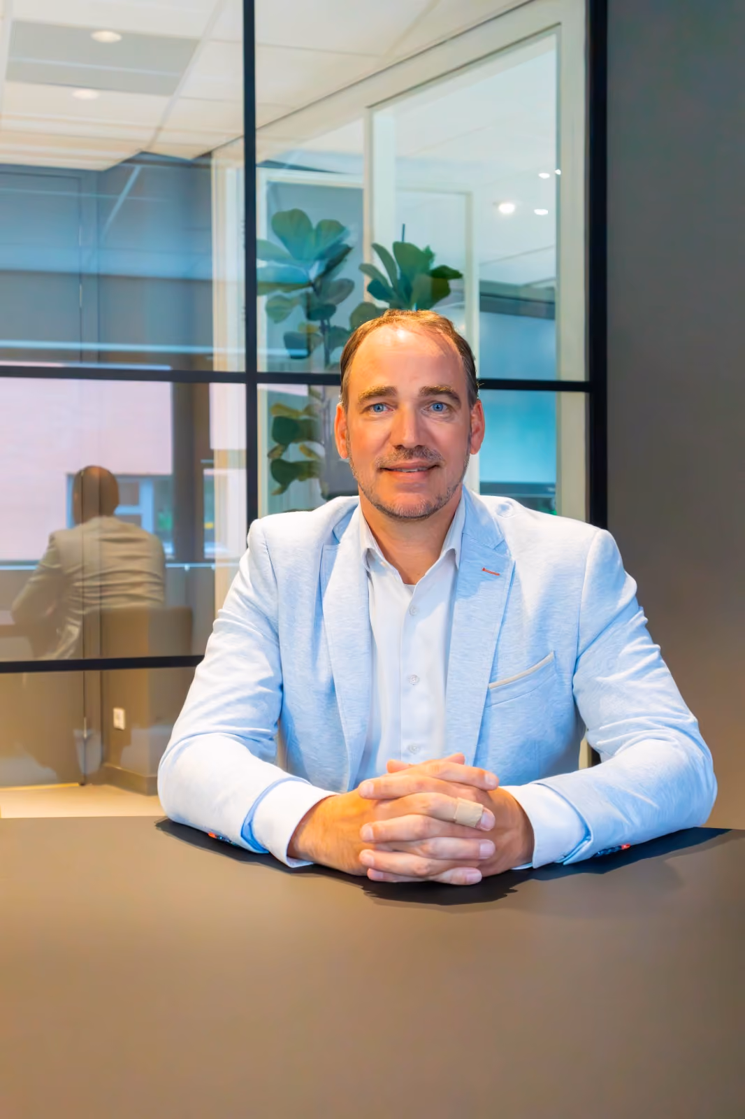Jort Zwolsman van Bonworks zittend aan tafel en kijkt in de camera