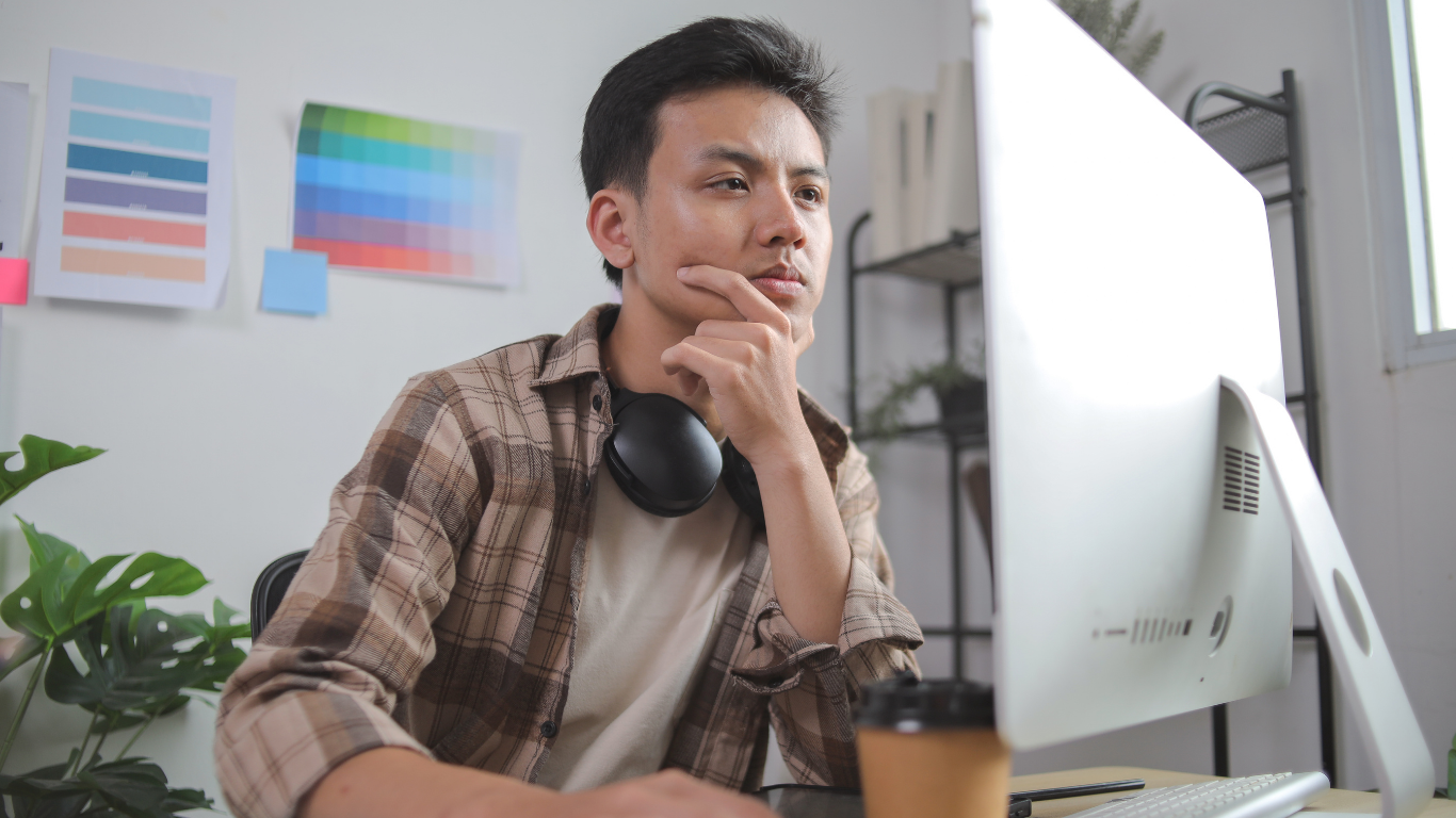Man sitting in front of a computer, thinking.