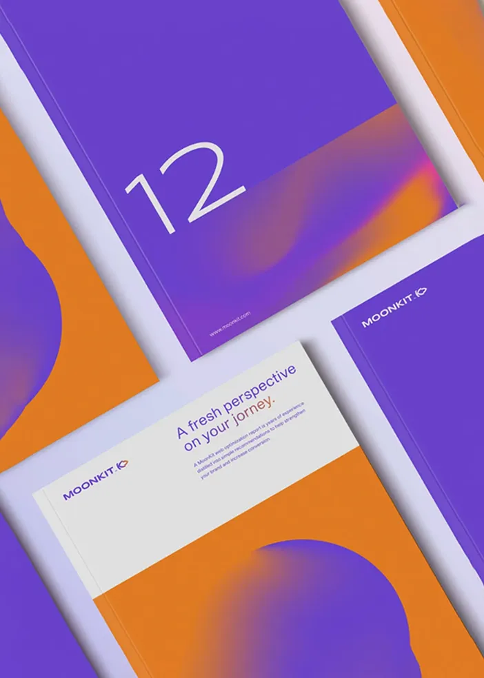 Purple and orange Moonkit brochures arranged on a light surface, one shows number 12, another has text.