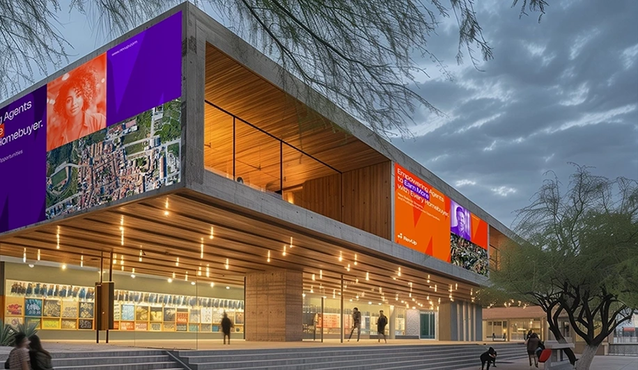 Modern building with large digital advertising banners showing real estate agent promotions at dusk.
