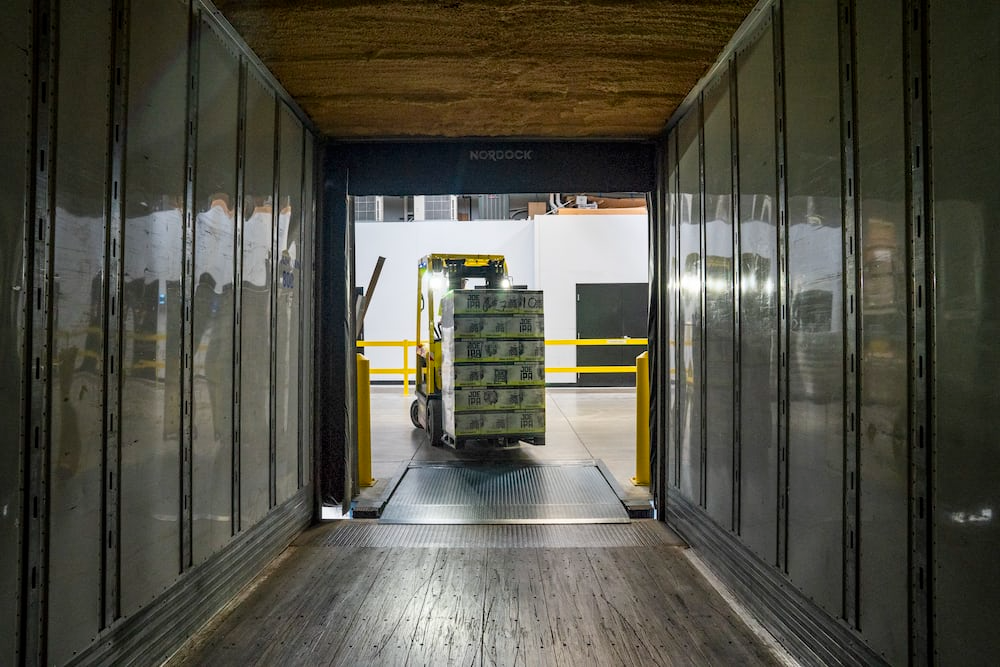 Forklift transferring goods into a container.
