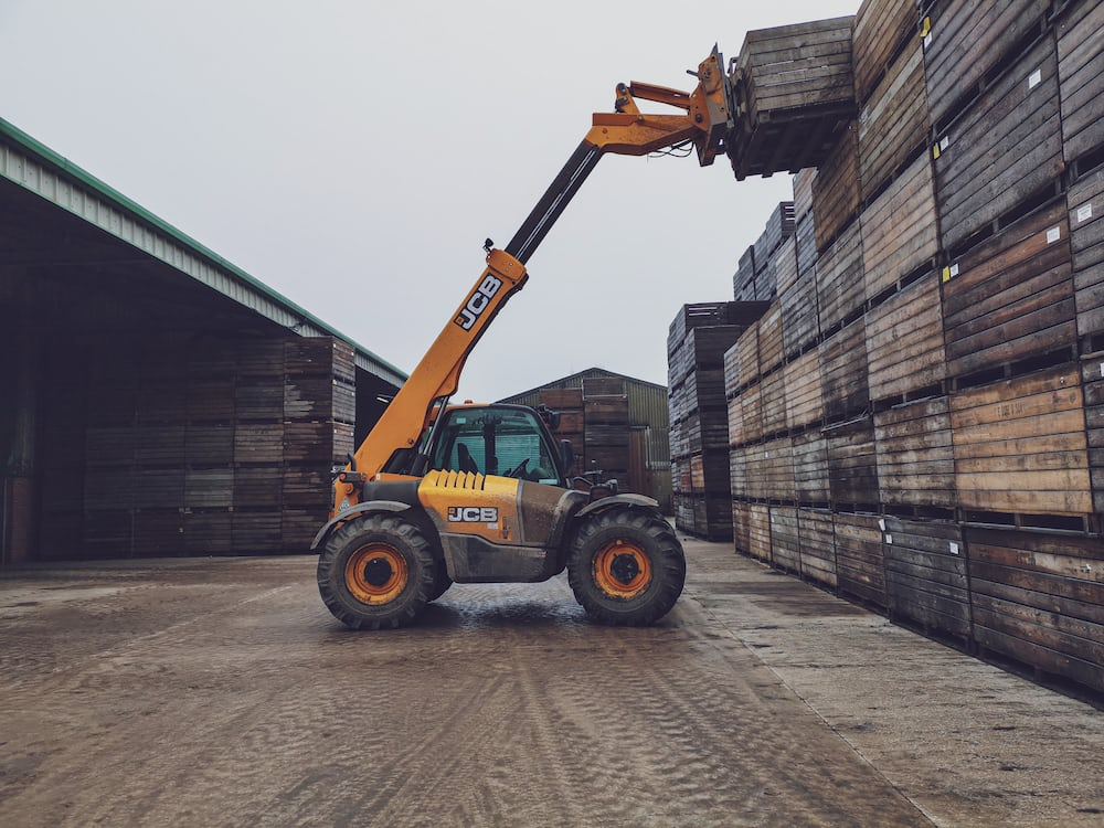 Forklift lifting wooded crate.