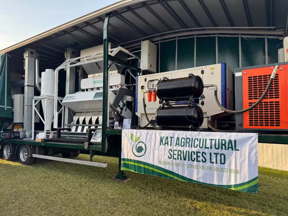 Agricultural sorting machine on trailer with a banner reading Kat Agricultural Services Ltd.