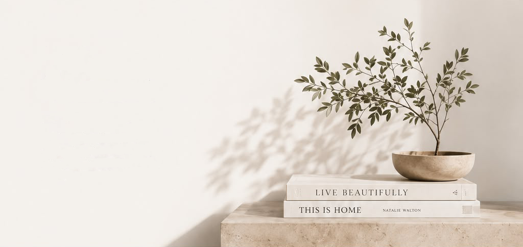 Leafy branch arranged in a bowl above design books
