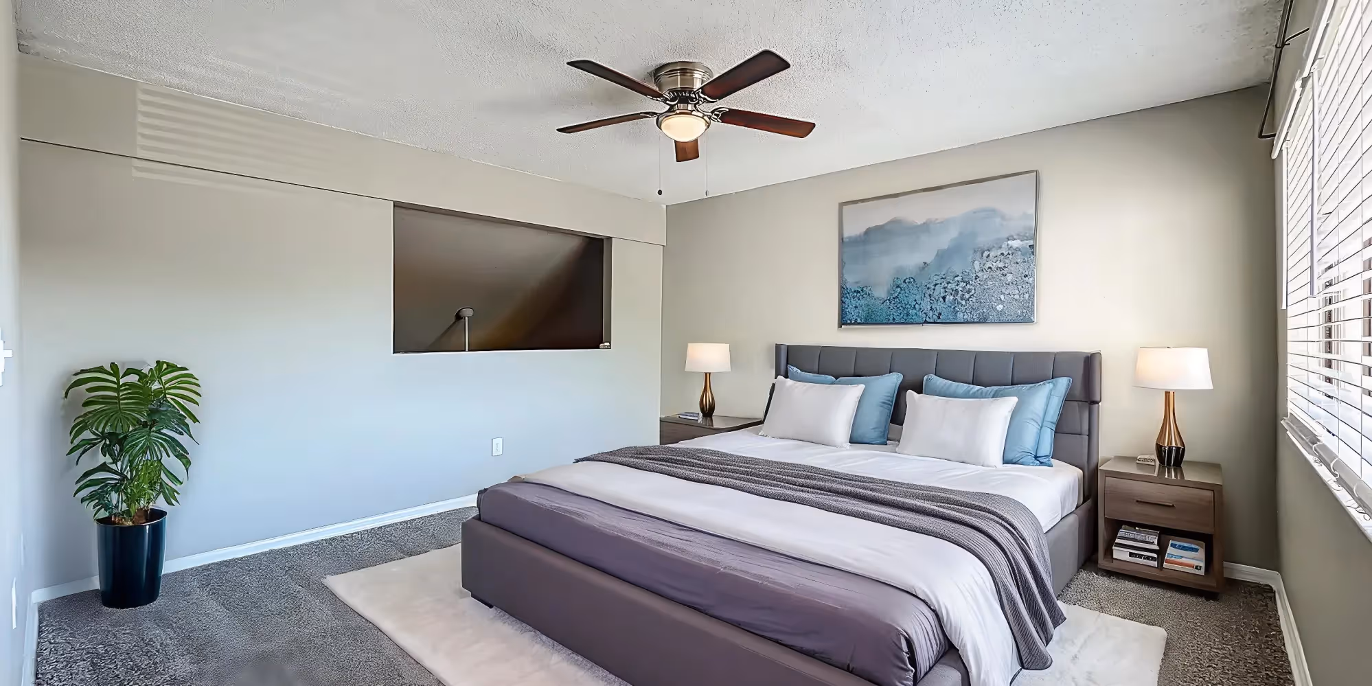 Bedroom with virtually staged furniture including bed, plant, and bedside table with lamp