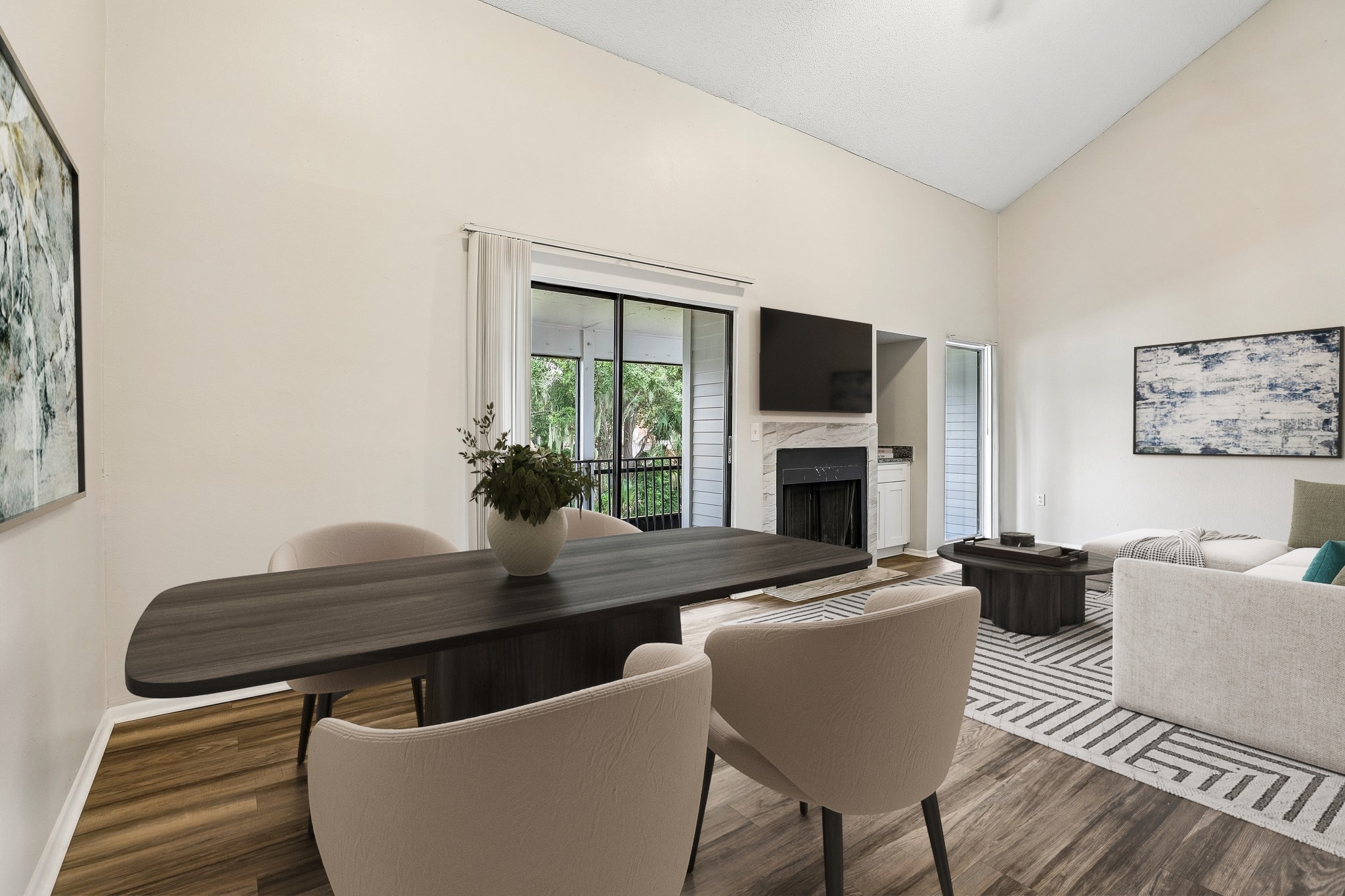 Living room with furniture including couch, coffee table, dining table, and bar stools.