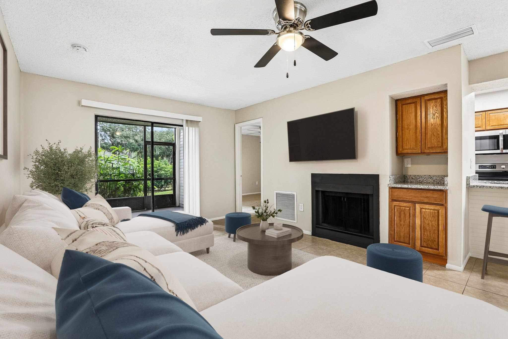 Living room with furniture including couch, coffee table, dining table, and bar stools.