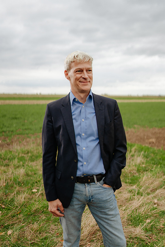 Geschäftsführer Thomas Andersen steht auf eine grünen Wiese.