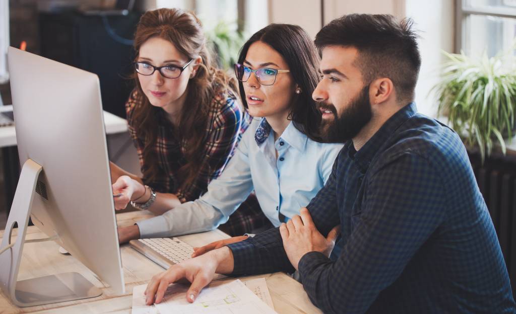 employees sitting at a desk and working