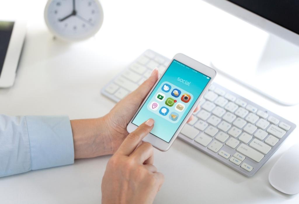 girl holding her phone with social folder open