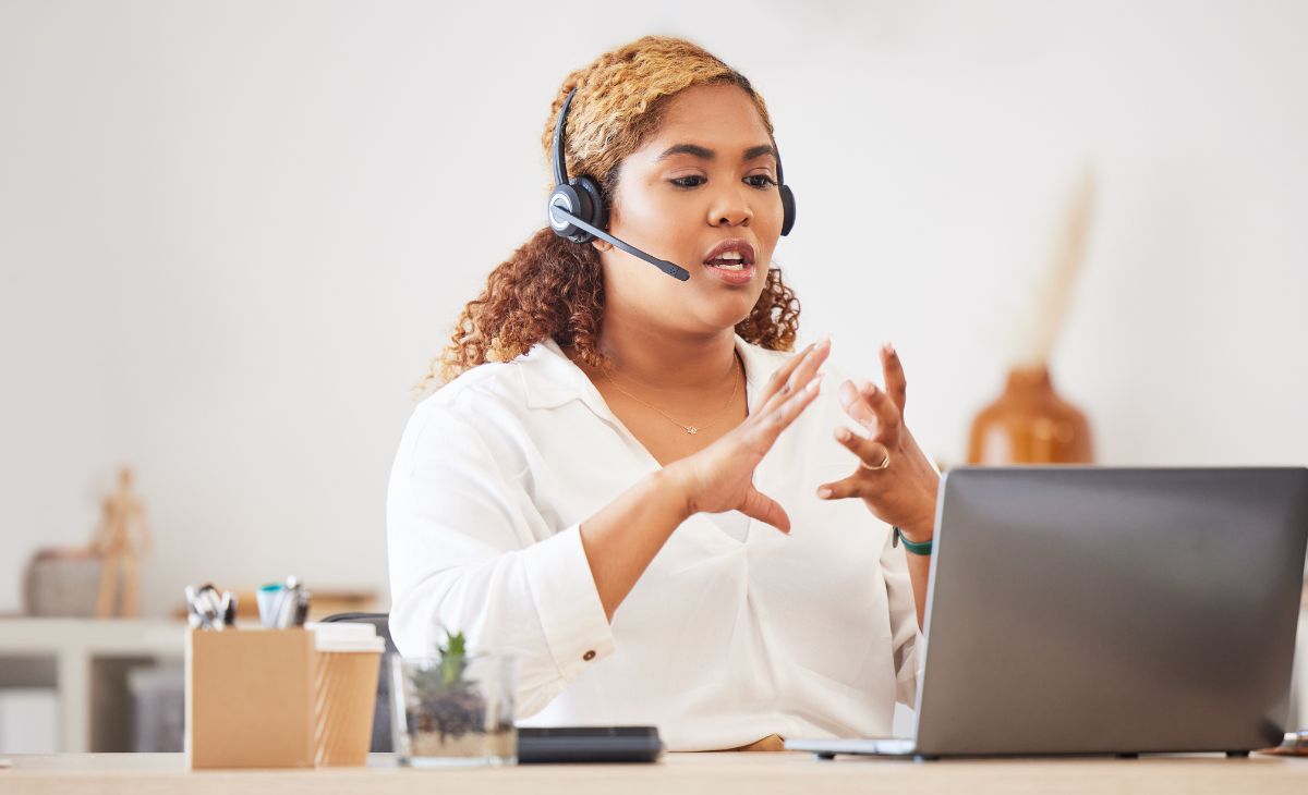 woman talking on headphones and working on a laptop