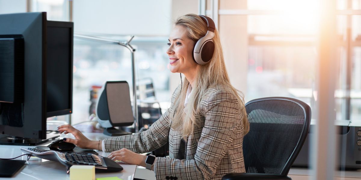 woman with headphones working on PC