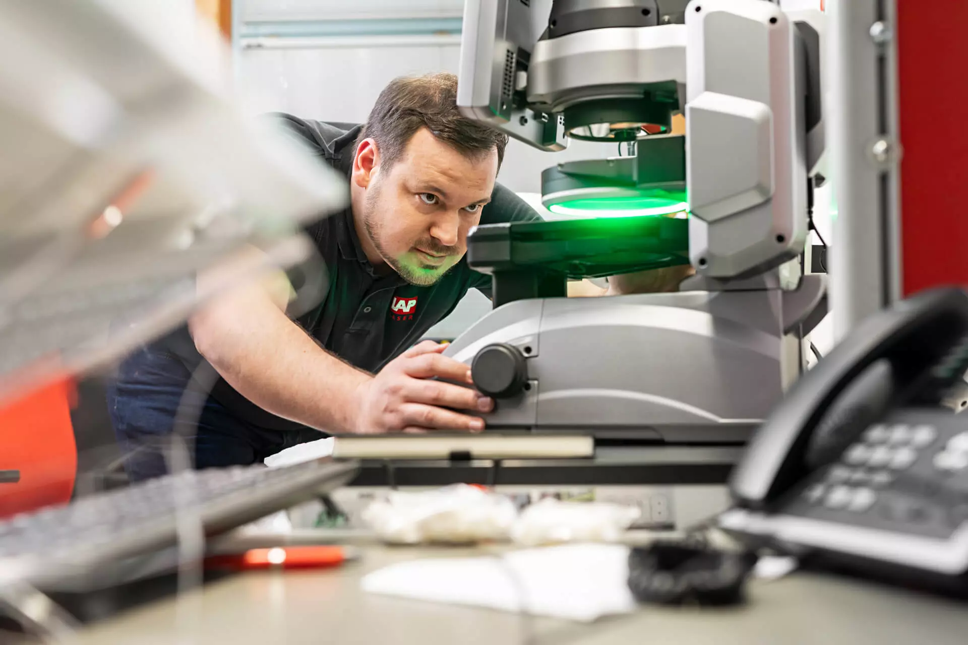Technician inspecting laser measurement equipment in a lab