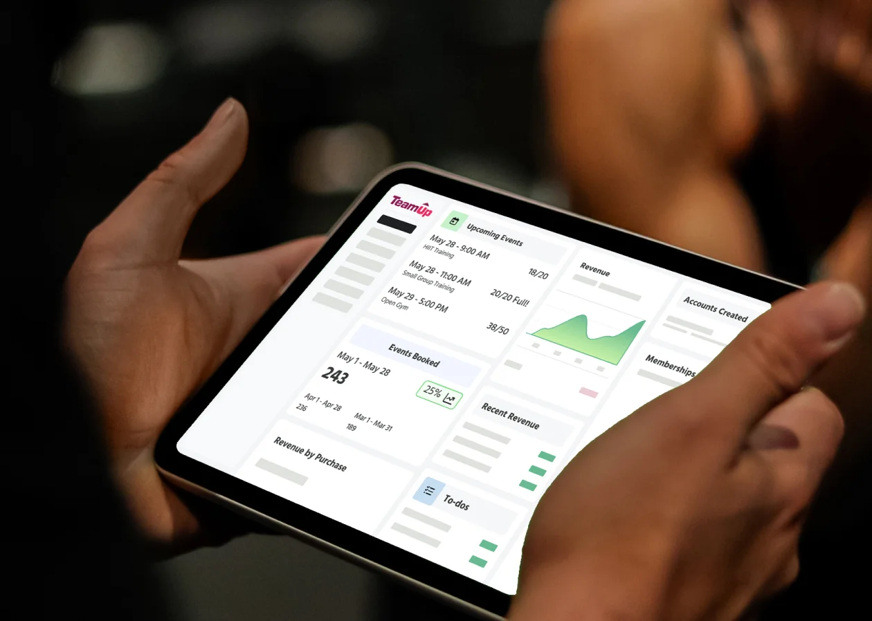 Photo of a gym owner looking at a TeamUp dashboard to get a sense of their business health