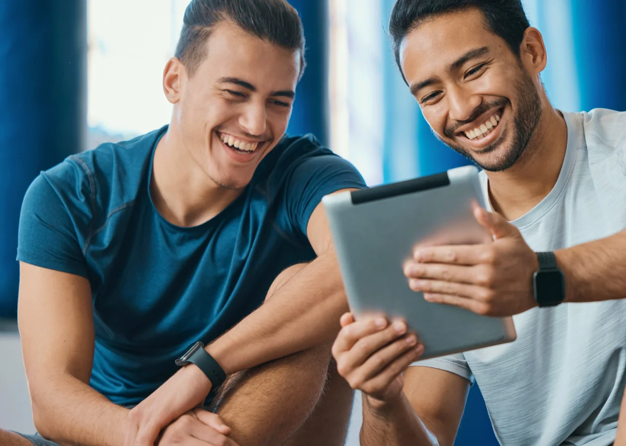 Gym owners looking at a tablet for updates on their business
