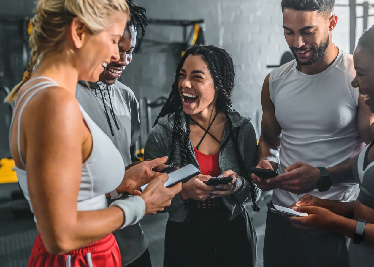 Gym employees having fun at work checking their phones for updates