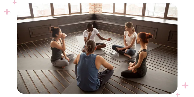 A group of staff members having a meeting on the floor of their studio.