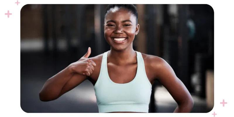 A smiling fitness instructor giving a thumbs up.