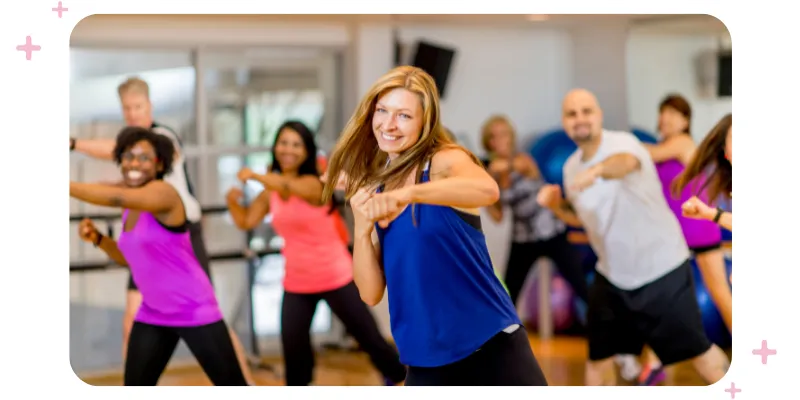 Group of gym-goers actively participating in a fun class