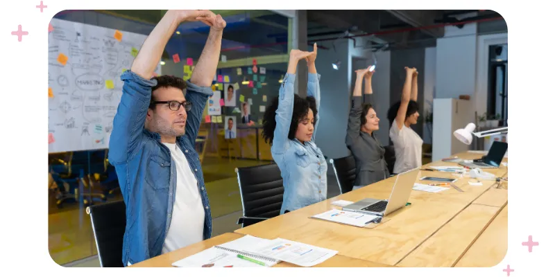 workers stretching at their desks to improve flexibility