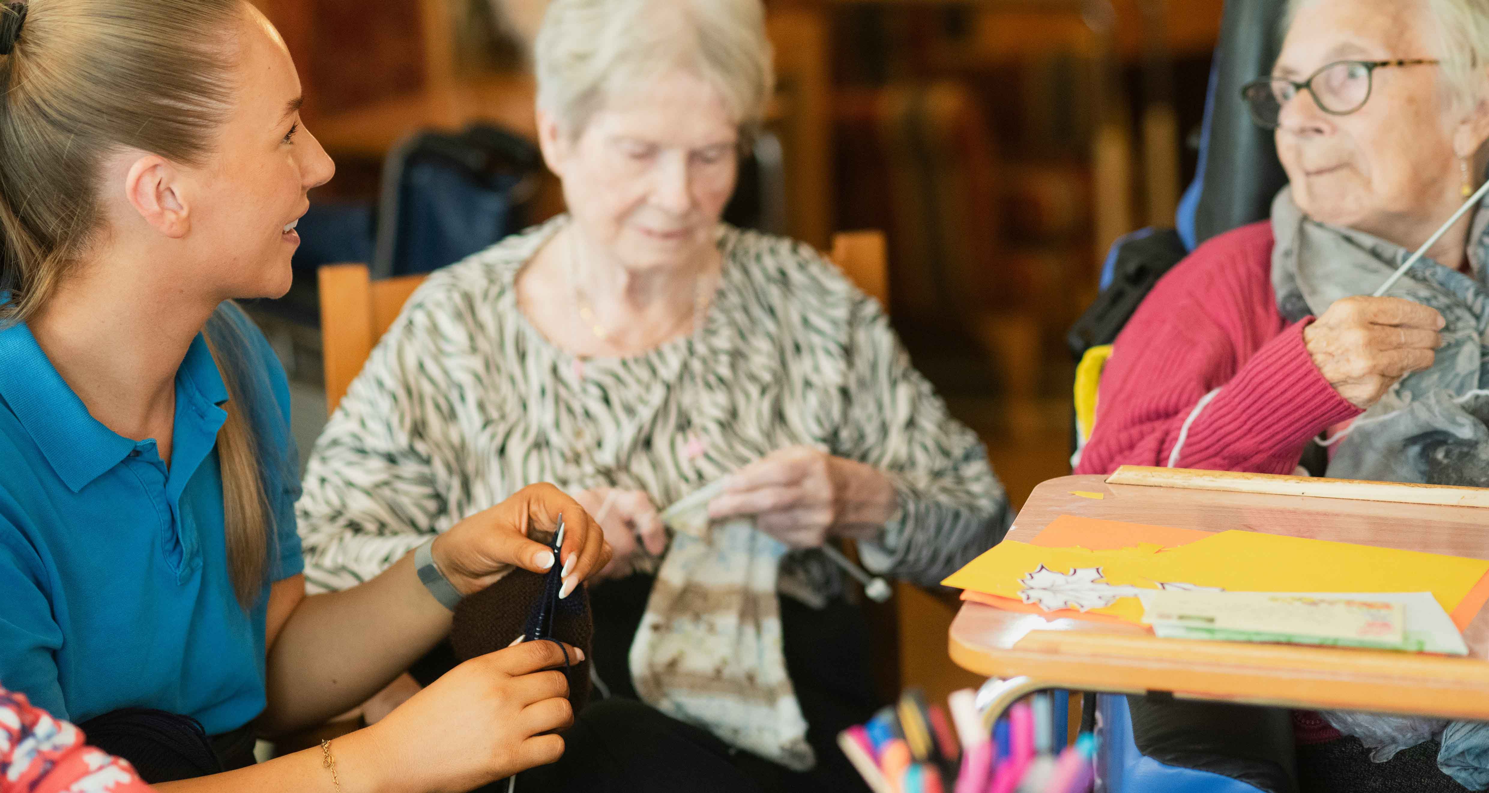 A group of elderly people talking with a nurse