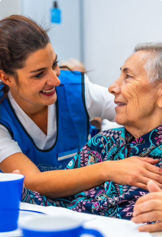 A care home nurse hugging an elderly lady