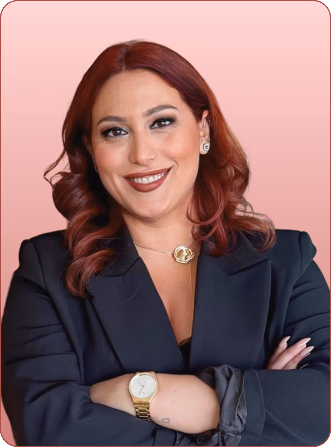 Koyu lacivert ceket giymiş, kolları çapraz ve güler yüzlü, kırmızı saçlı kadın.