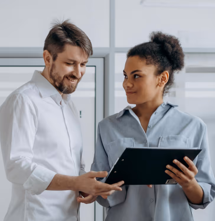 2 colleagues looking at a binder