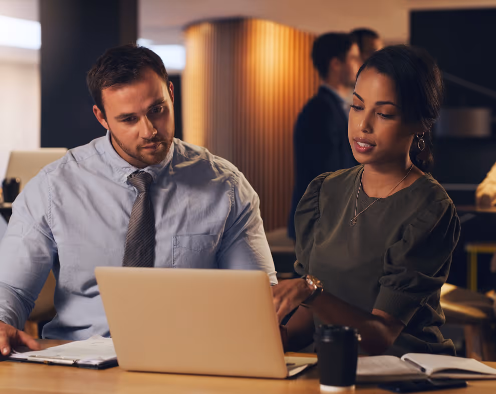 A man and a woman looking at a laptop