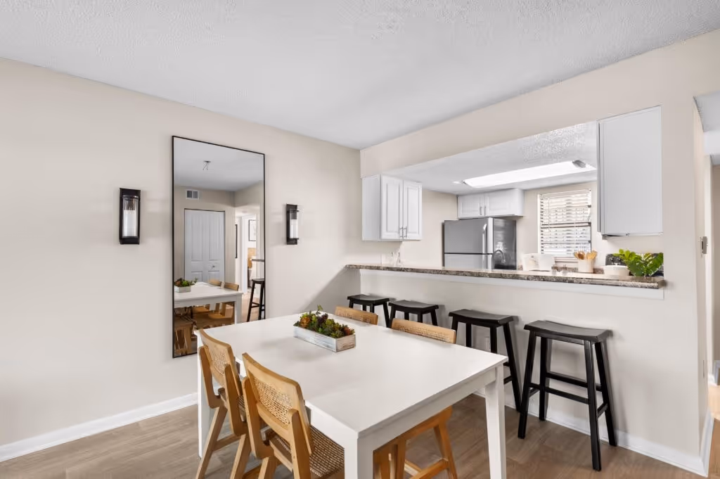 Dining area with table chairs and view of kitchen with breakfast bar