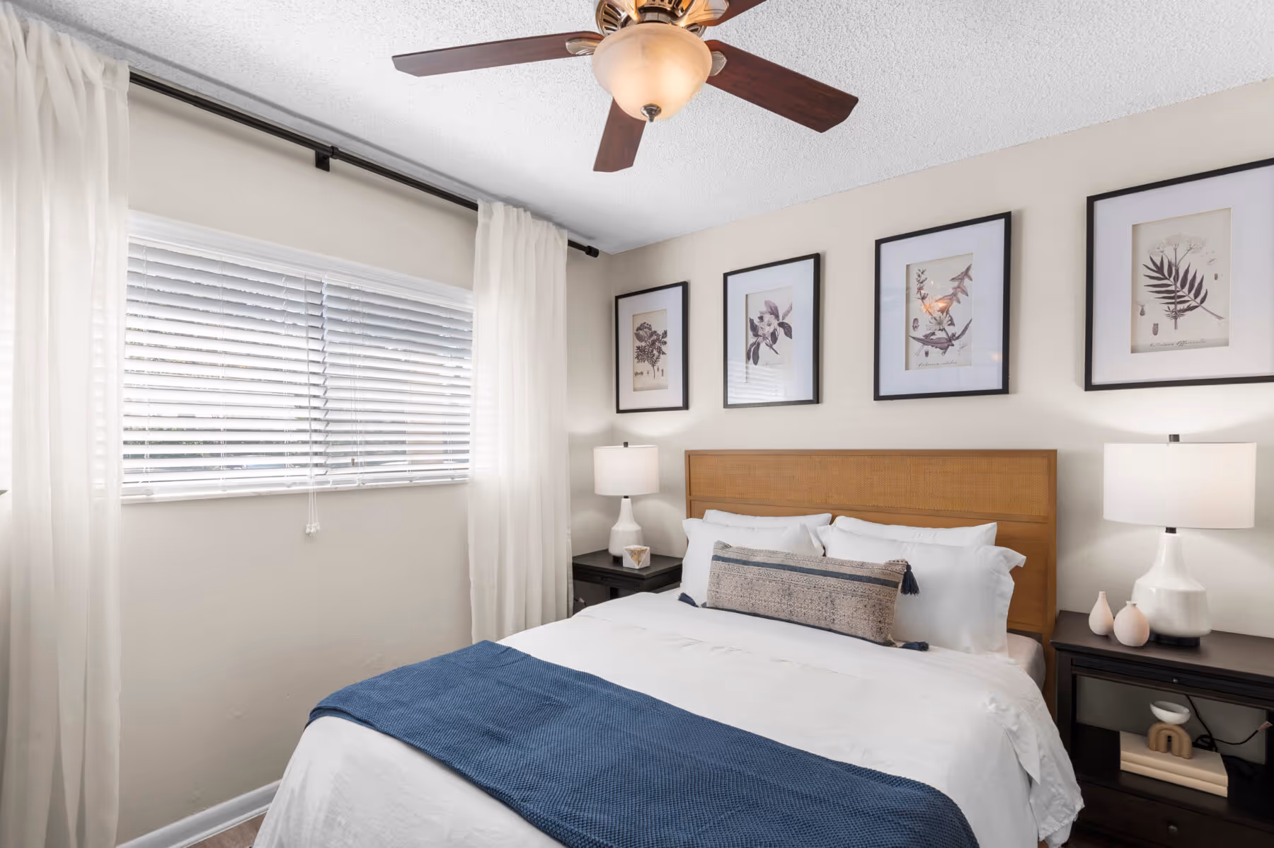 Bedroom with bed, wall art, ceiling fan, and large window