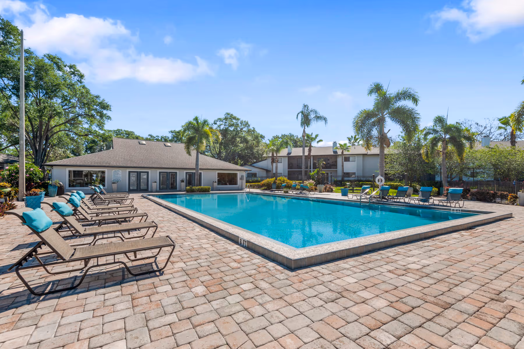 Swimming pool with lounge chairs, view of exteriorand trees