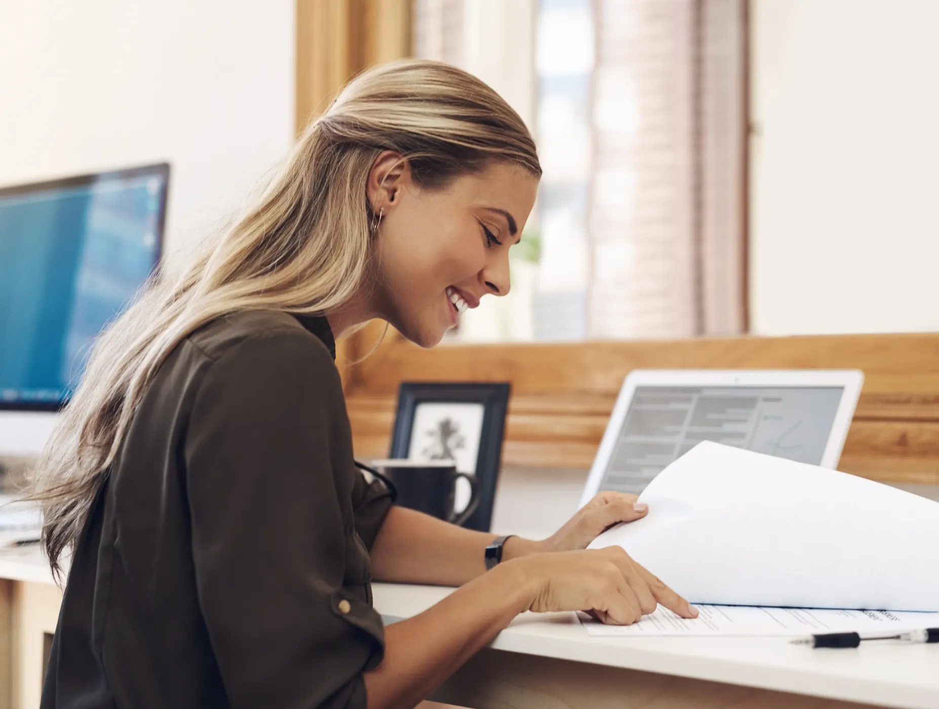 A woman sitting at a desk with a laptop.