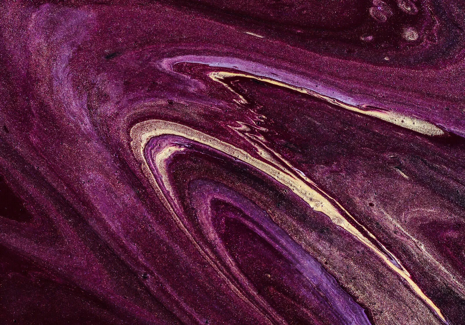 Abstract swirling pattern in shades of purple, violet, and gold with glittery texture.